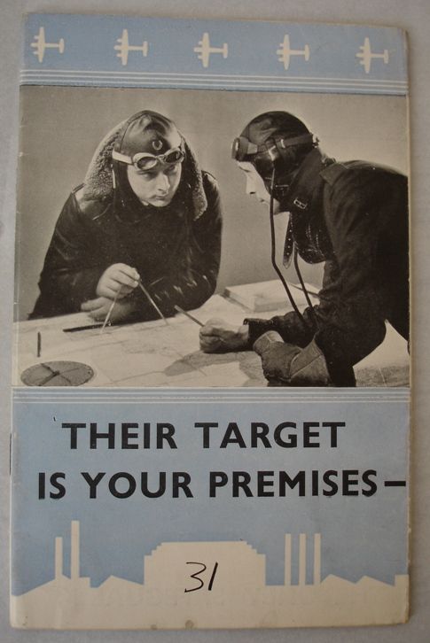 An original leaflet, with a black and white photograph of two pilots in flight gear studying a map. The page above and below is pale blue, with a repeating pattern of white plane silhouettes. Black text below reads: "Their target is your premises".