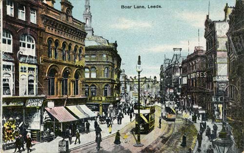 Colour tinted postcard of Boar Land in Leeds in 1906.  It shows trams on the street, lots of people walking around and shops open for business