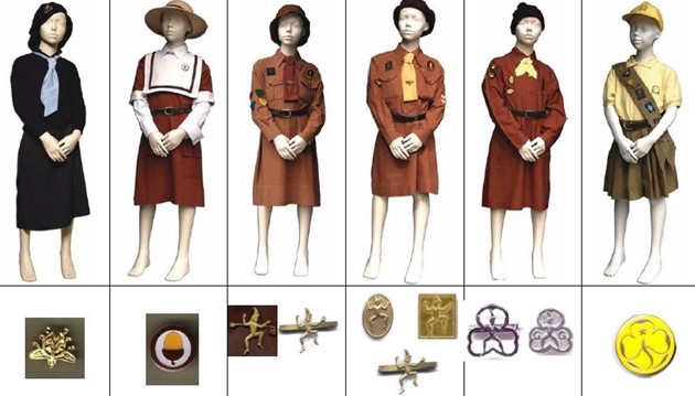 Colour photograph showing a range of manikins with different brownie uniforms on.