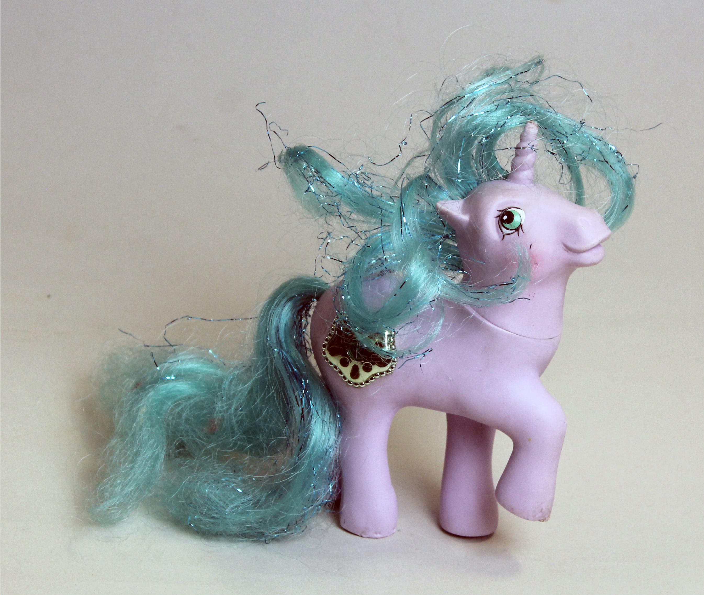 Colour photograph of a pale purple soft plastic  unicorn pony, with blue mane and tail.
