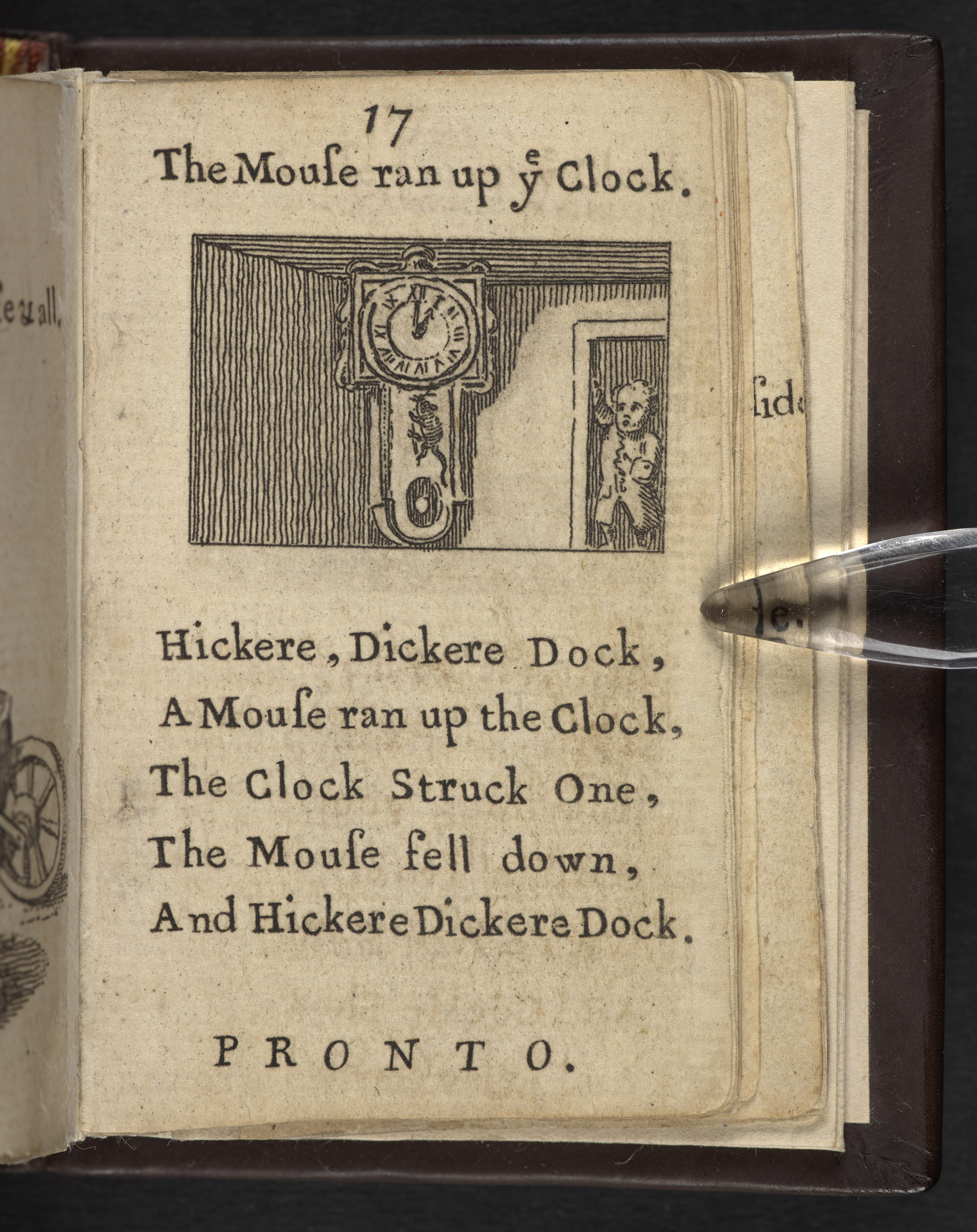 Page from a tiny book with a rhyme printed on it and a picture of a clock and a mouse.