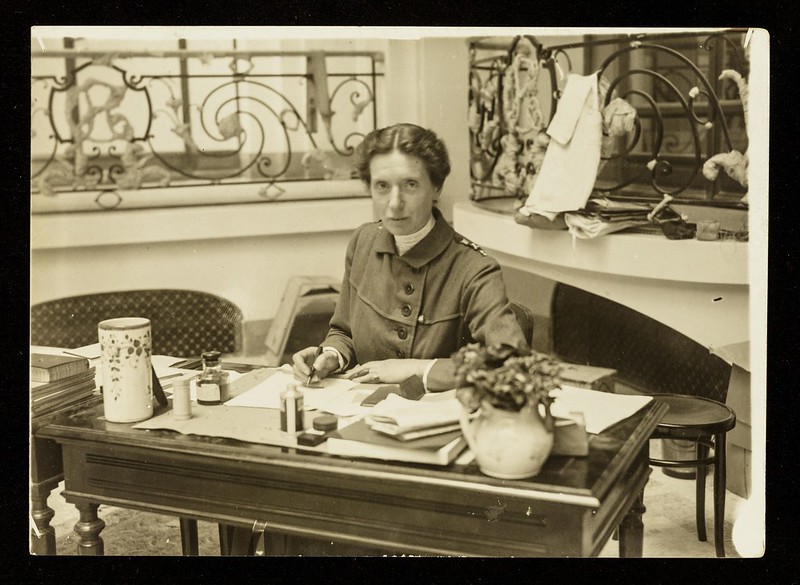 Black and white photo of Flora Murray sitting at her desk