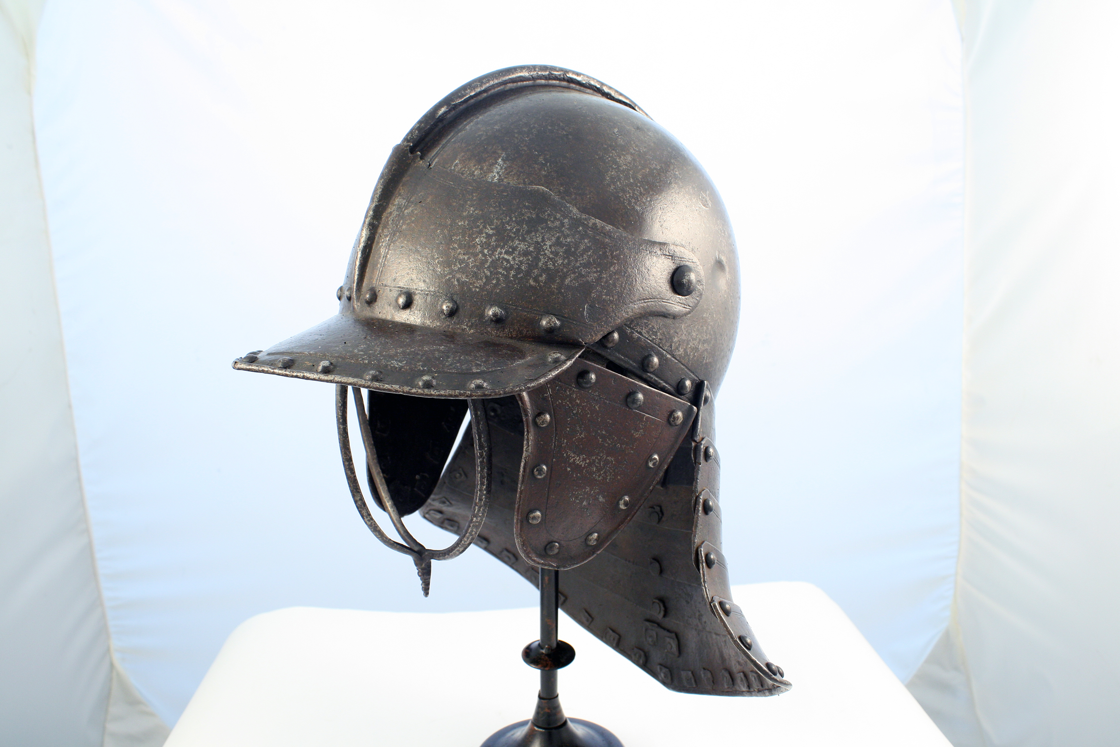 Metal helmet worn by Civil War cavalry soldiers displayed on a metal stand