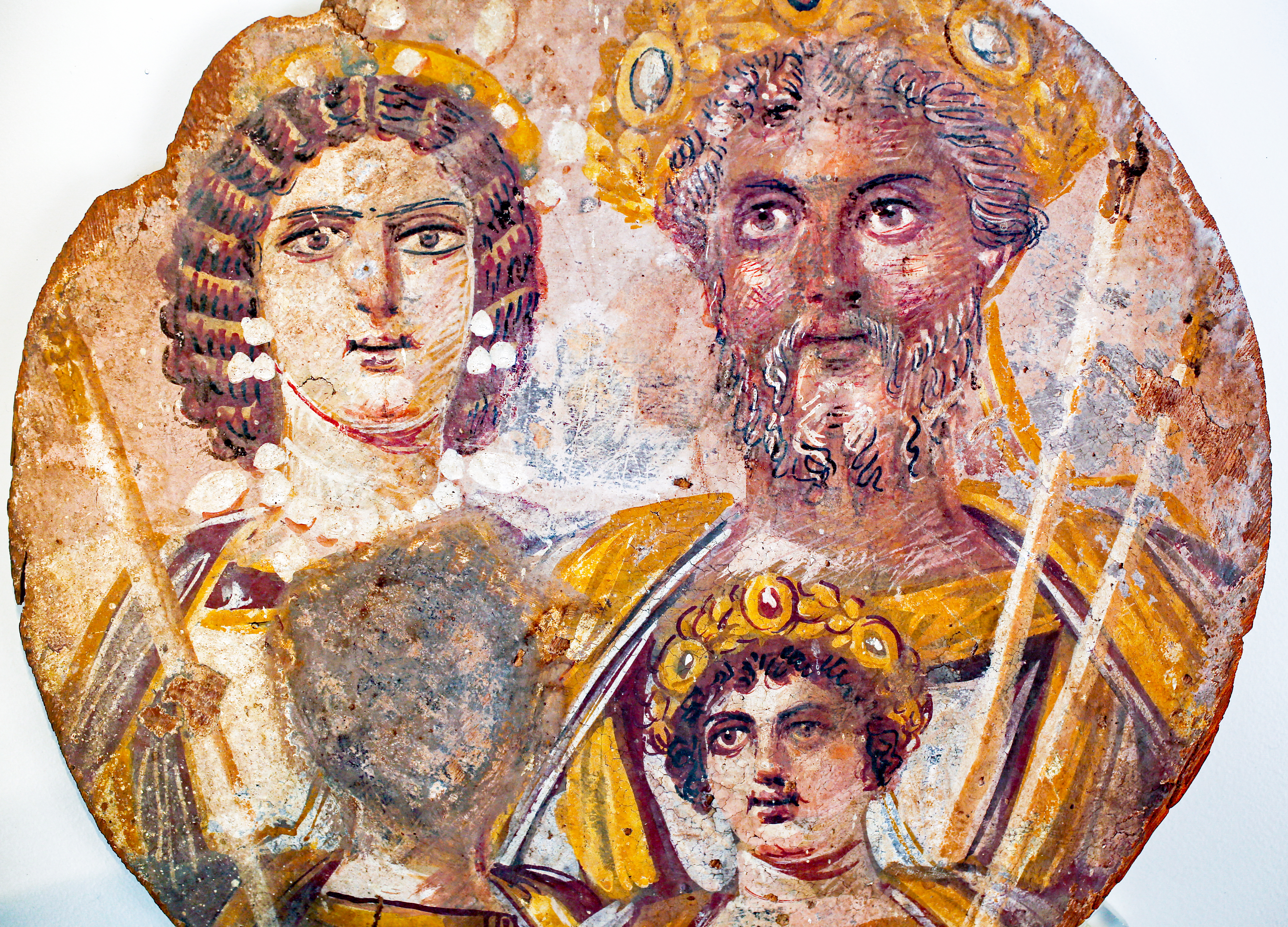 Colour photograph showing a black man, a lighter skinned woman and a child. The man and woman are wearing golden crowns