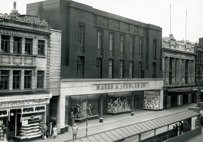 Black and white photo of department store with signage above ground floor entrance 'Marks & Spencer Ltd'