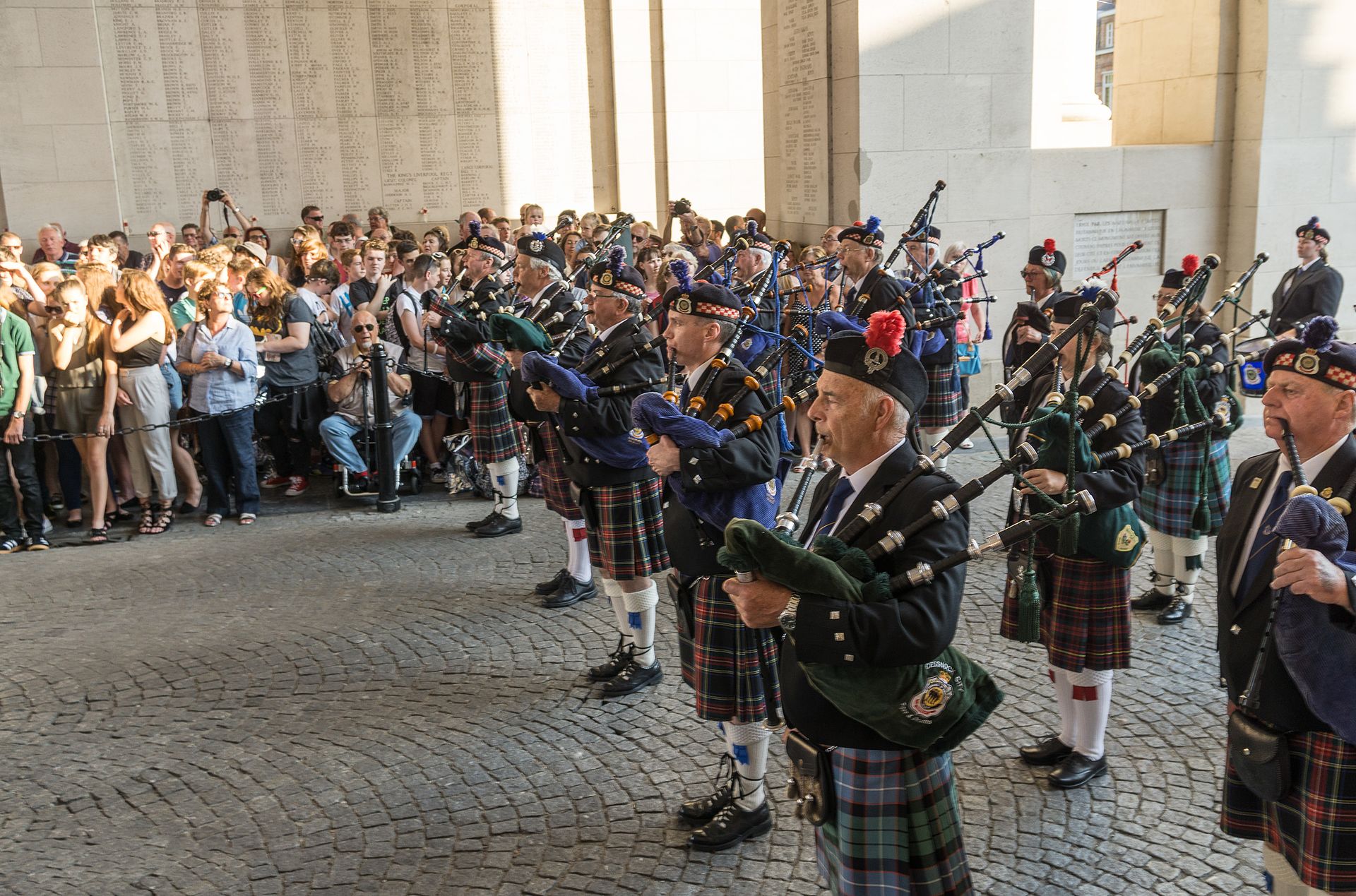 Coloured photograph showing rows of bagpipe players in traditional Scottish dress.