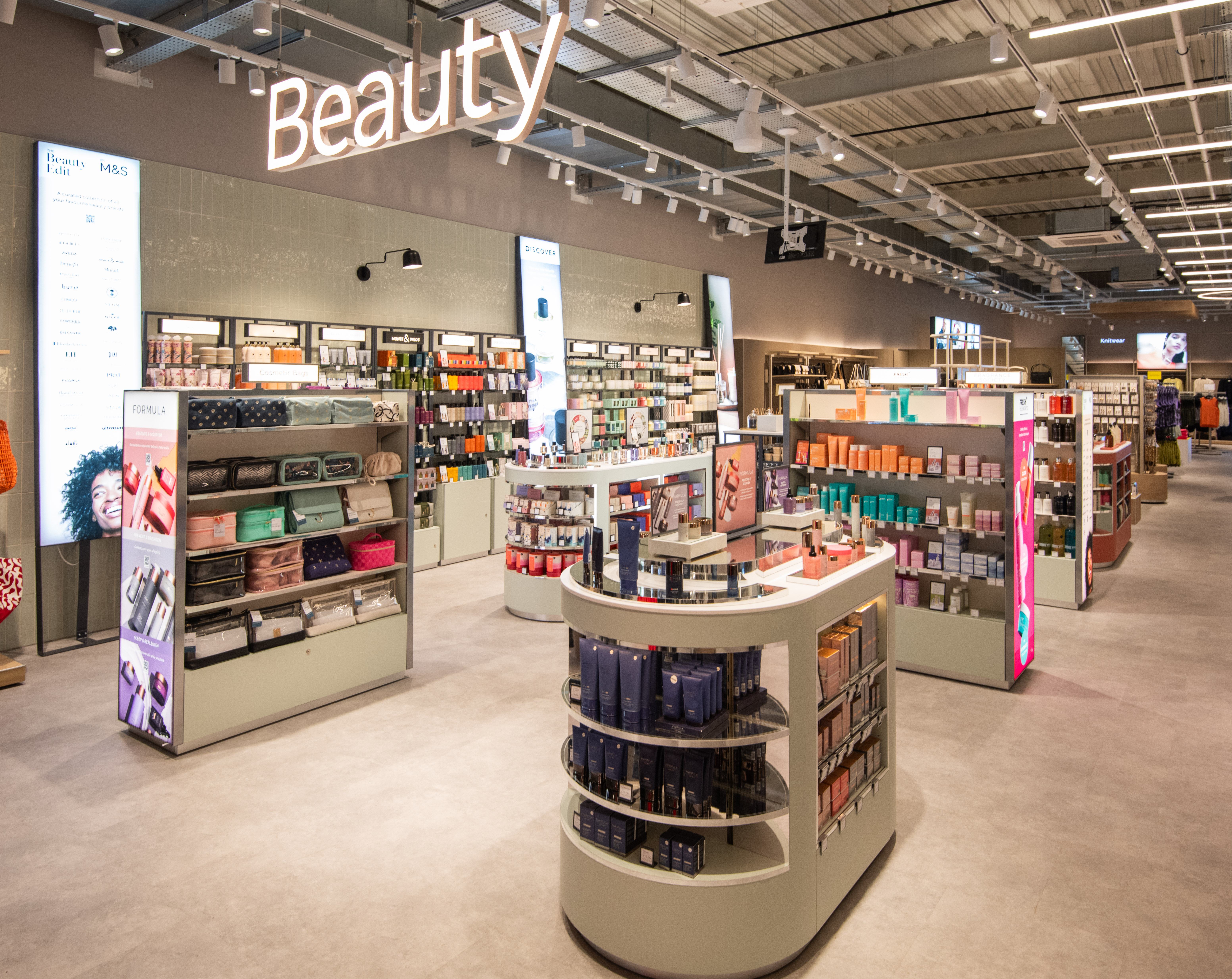 Bright, modern Marks & Spencer store interior with neatly arranged skincare and makeup products. Illuminated displays and signs create a welcoming atmosphere.