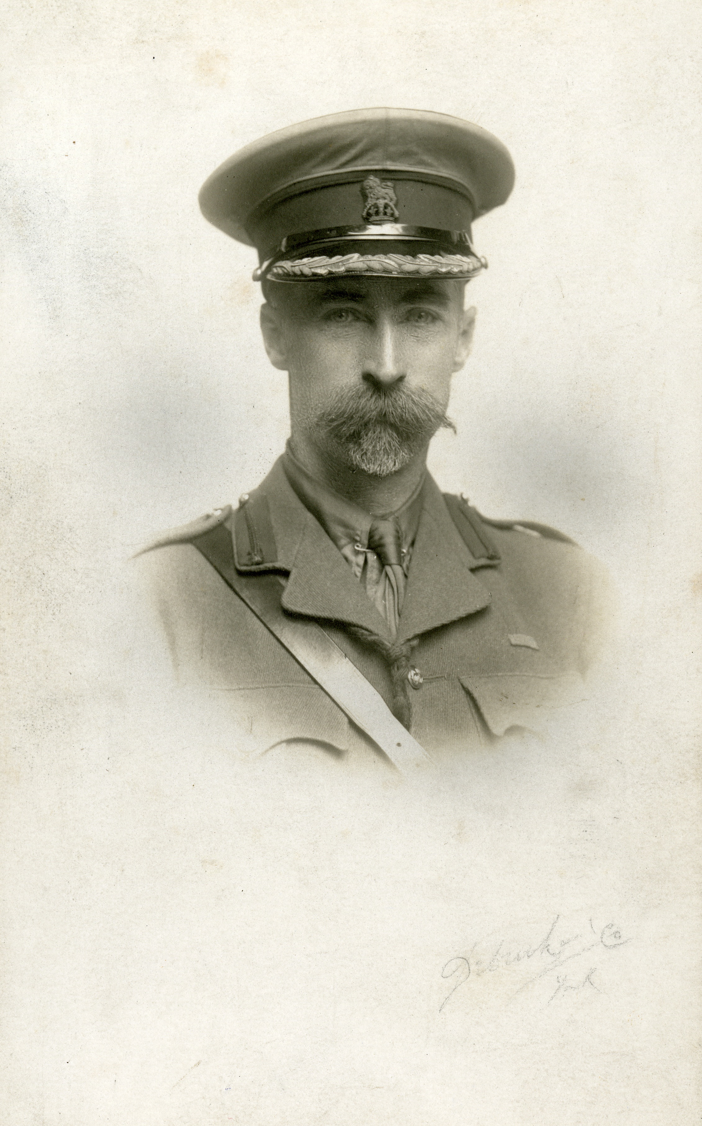 Portrait of a military officer in uniform, featuring a peaked cap and a prominent mustache.