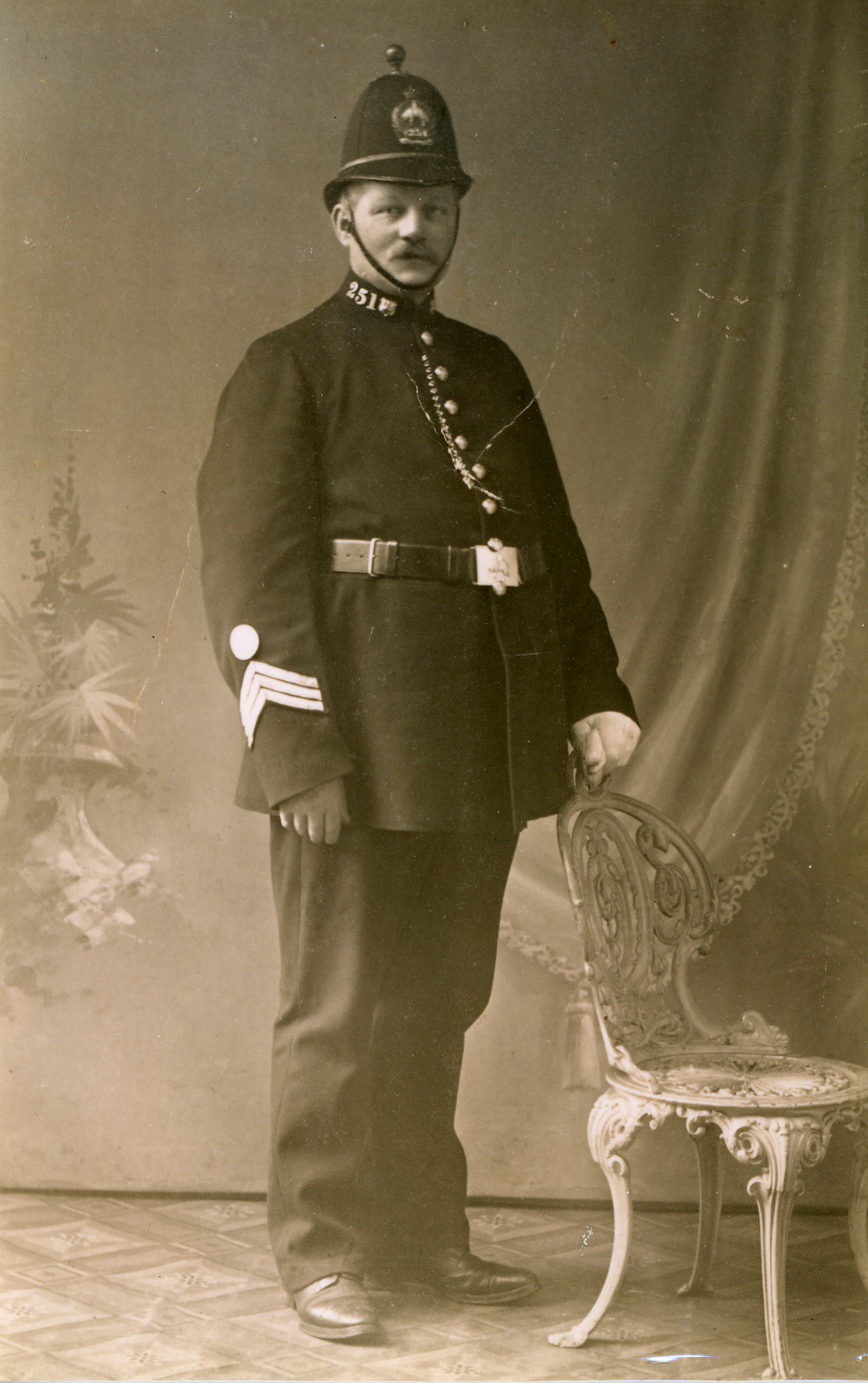 Photograph shows John Horner in police unifrom with a tall helmet.  Three chevrons on his sleeve indicate he is a sergeant.