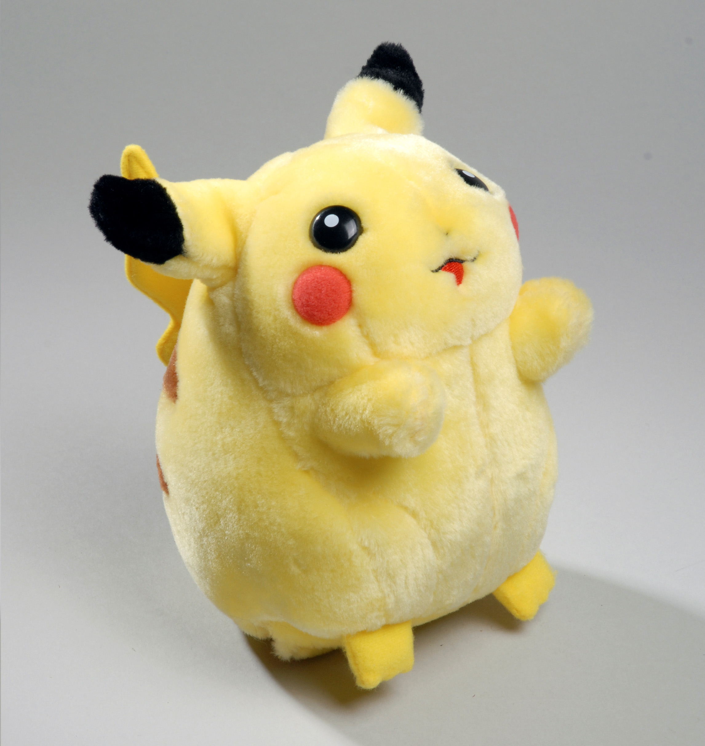 Colour photograph of a small yellow monster soft toy.