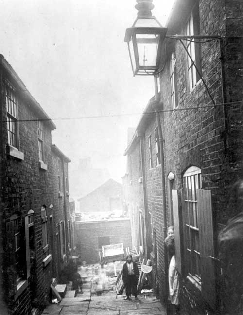 Black and white photograph showing a cramped yard in a poverty stricken area of Leeds