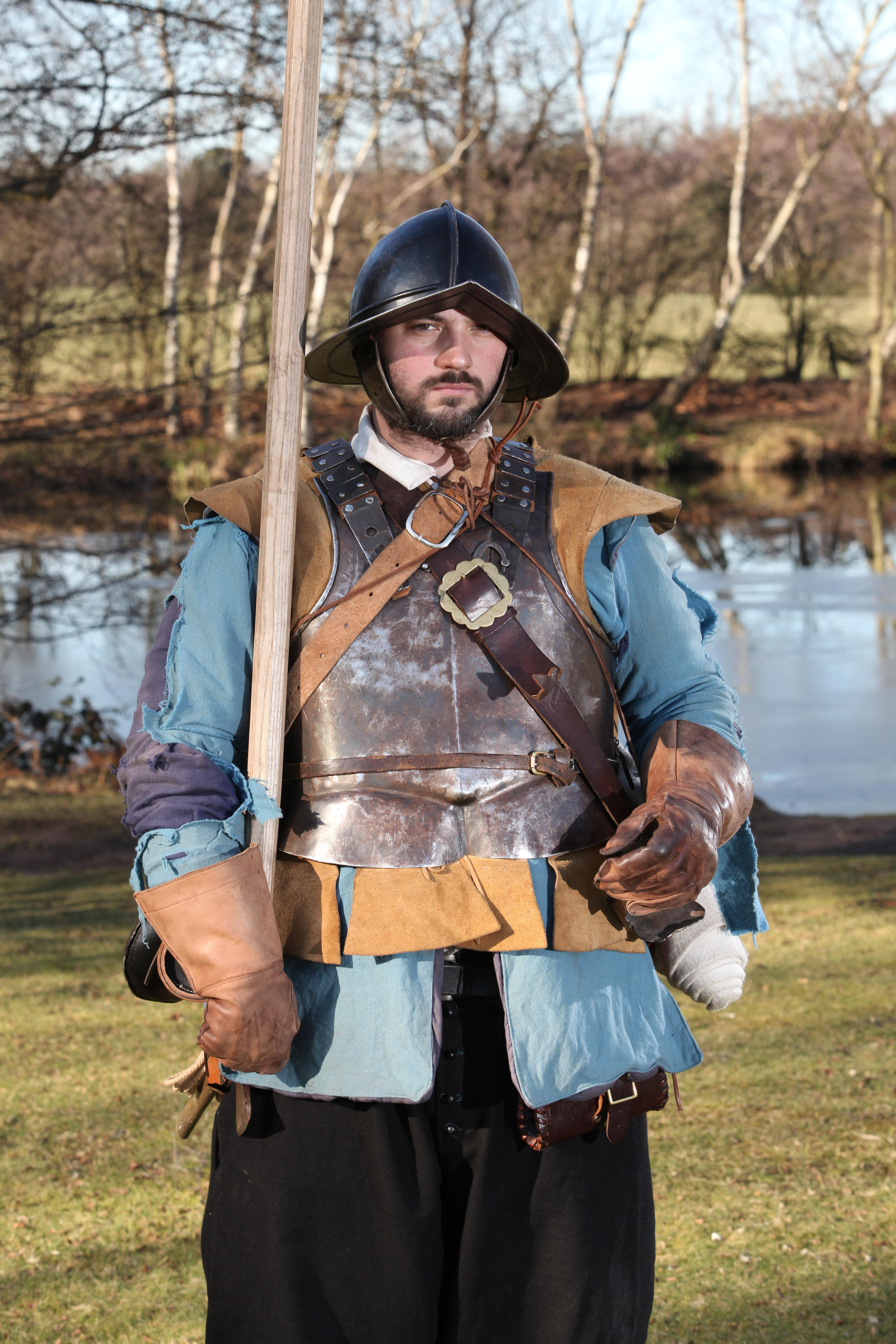 Photo of man dressed in civil war breastplate and helmet and holding a wooden pike
