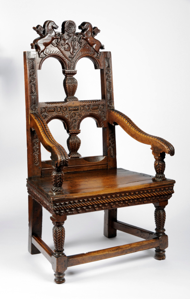 Colour photograph of a wooden chair, richly decorated with carvings