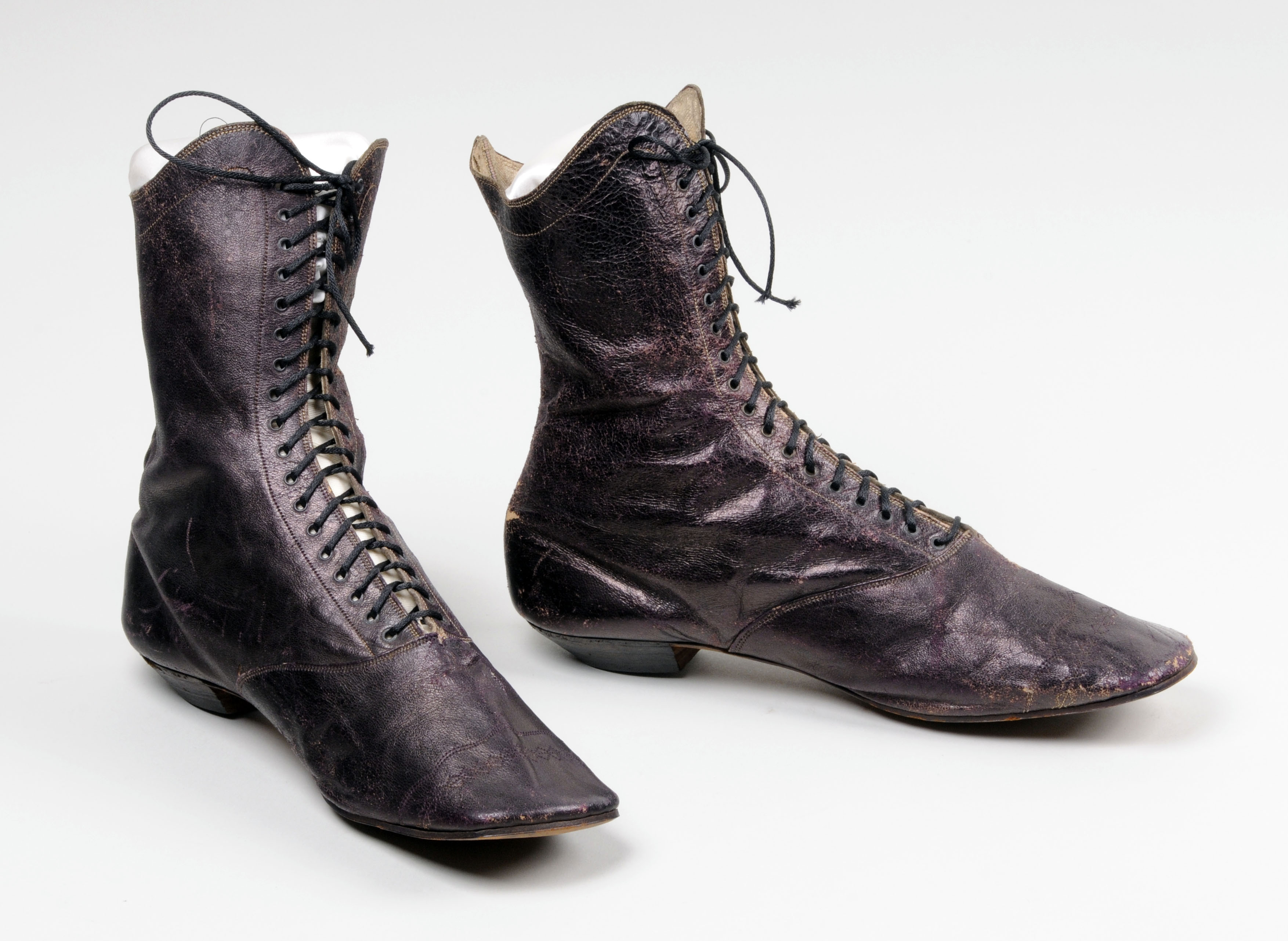 A pair of dark maroon boots that rise above the ankle, half way up the calf.  They are laced.