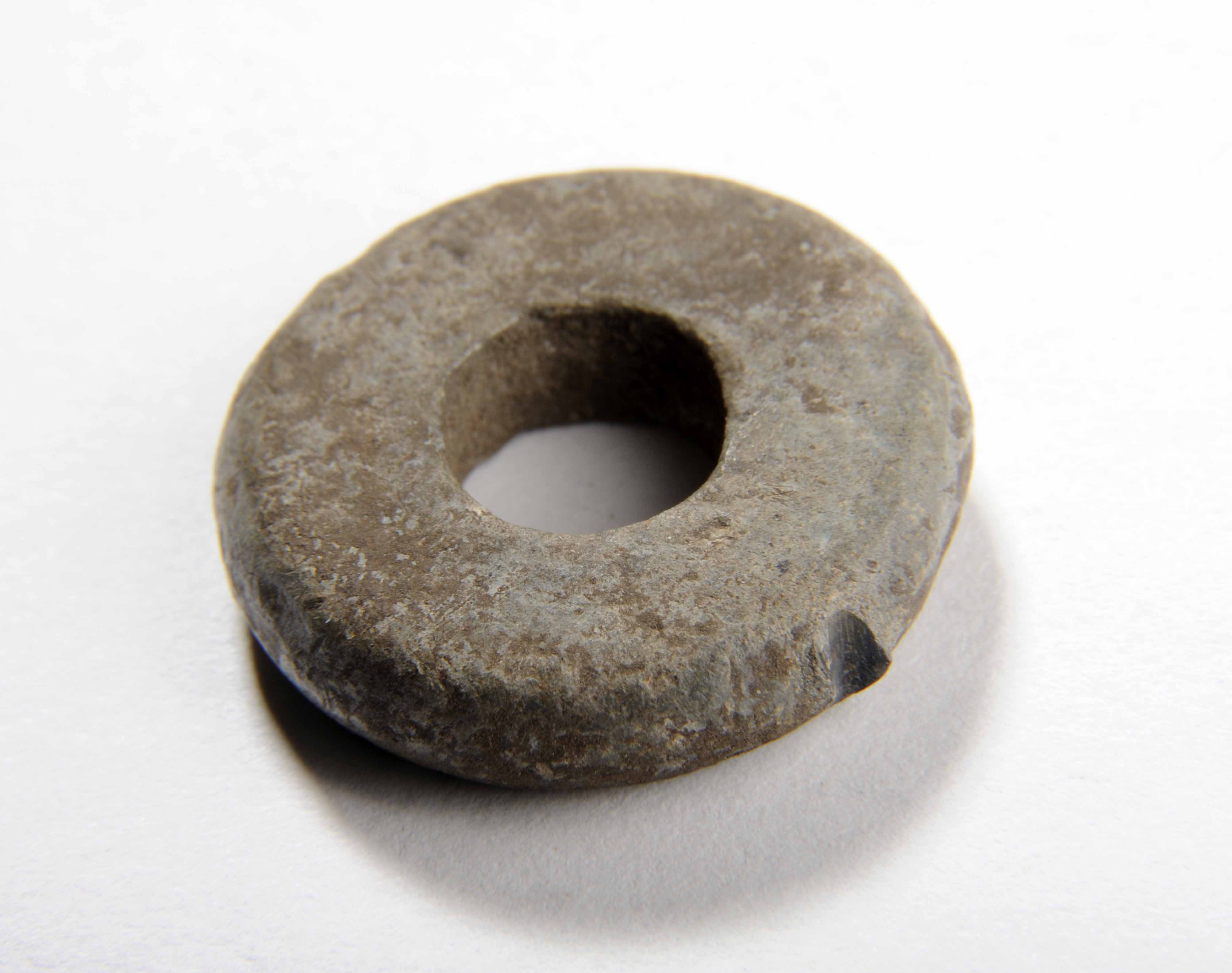 Lead spindle whorl in the shape of a flat doughnut