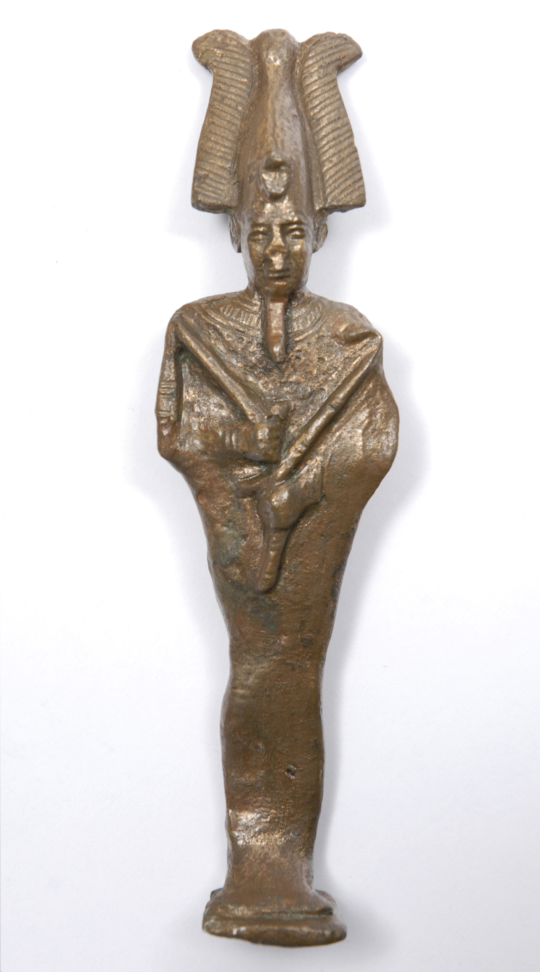 A figurine of the God Osiris complete with feathered crown, royal sceptre and flail showing his position as god of the Underworld.