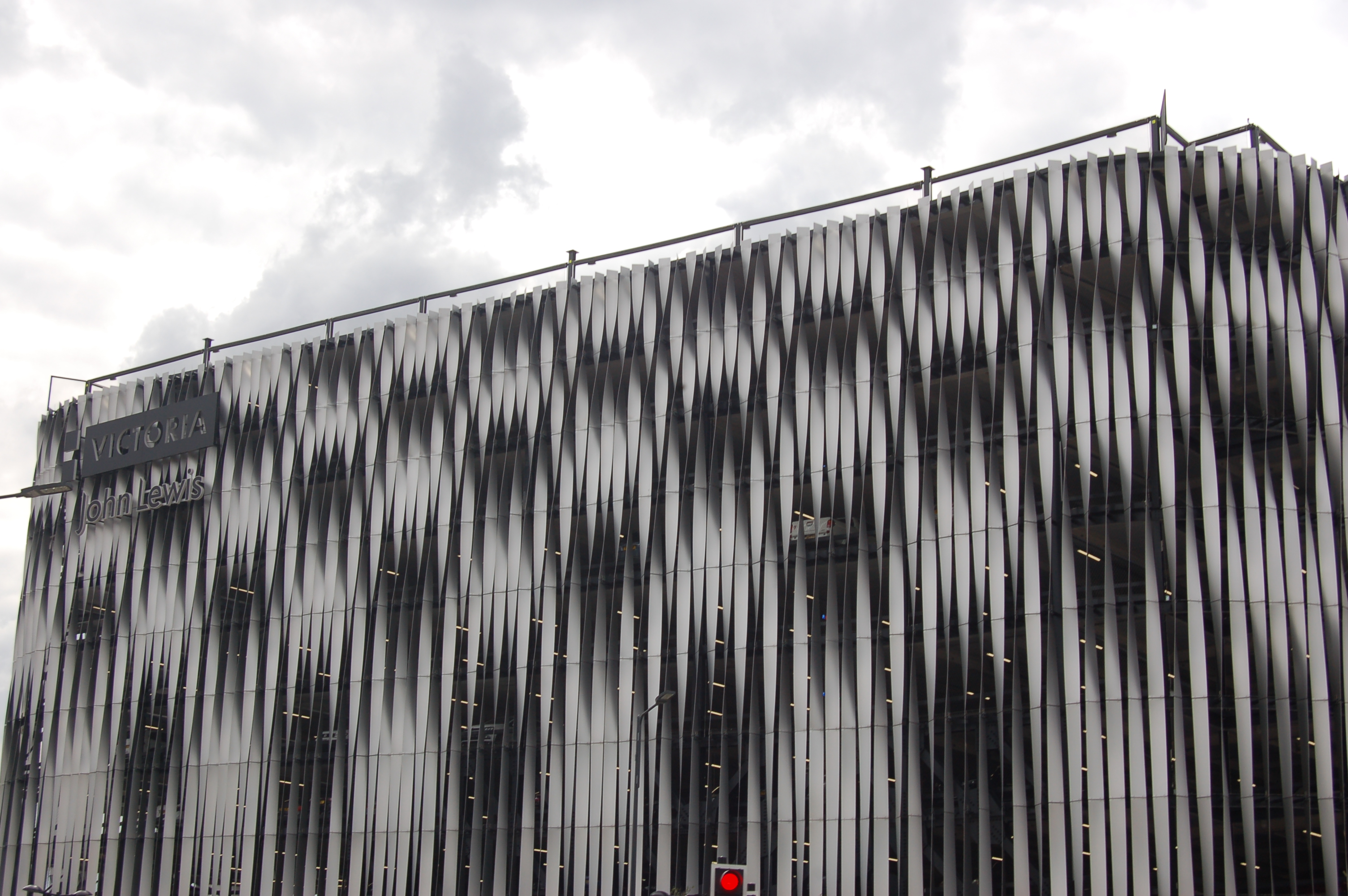 Contemporary photograph of a building made from verticle strips of twisted metal, creating a striking  overal geometric effect.
