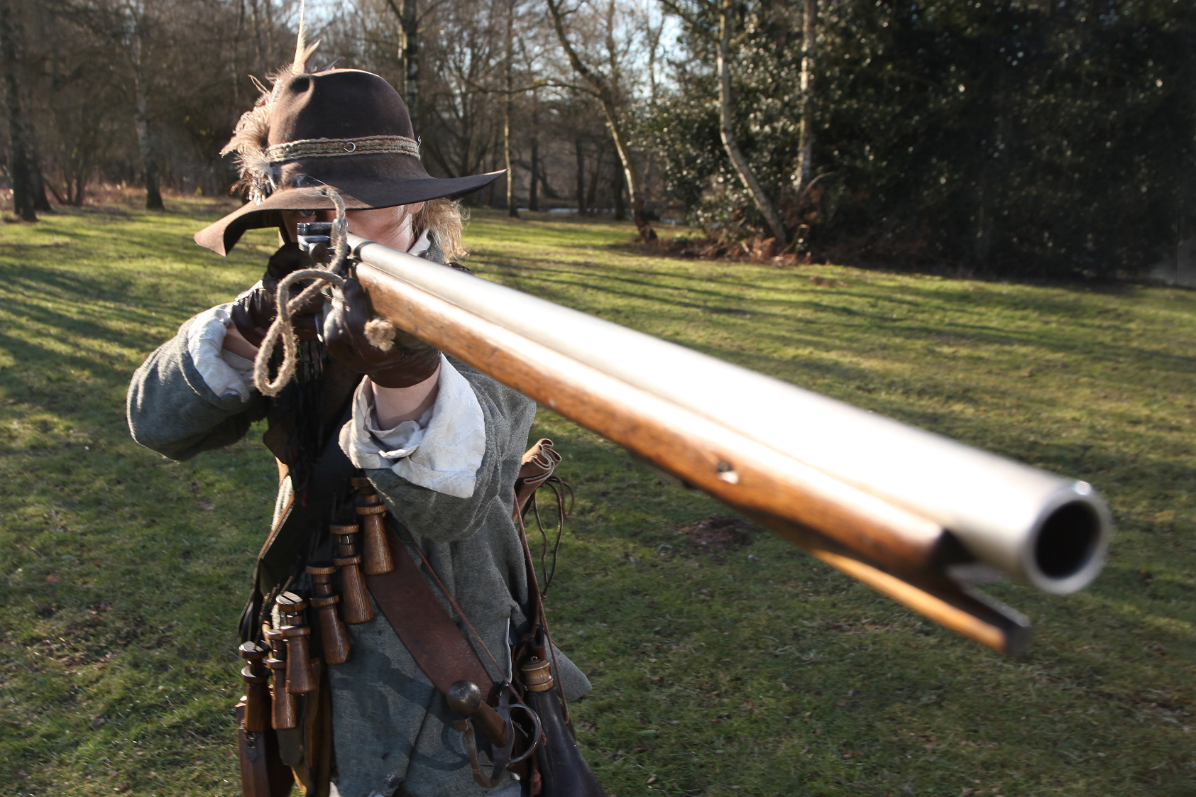 Photo of man in civil war costume aiming a musket towards the camera