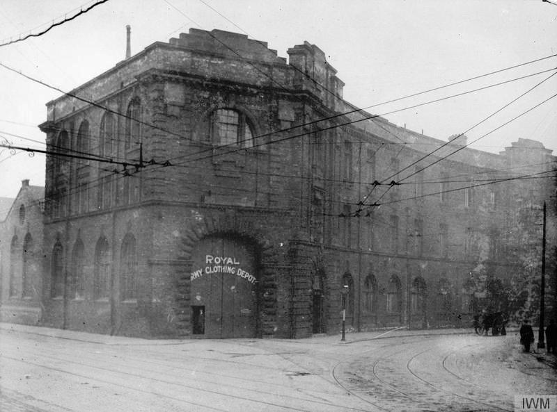 Black and white photo of Royal Army Clothing Depot in a city centre with overhead tramlines visible