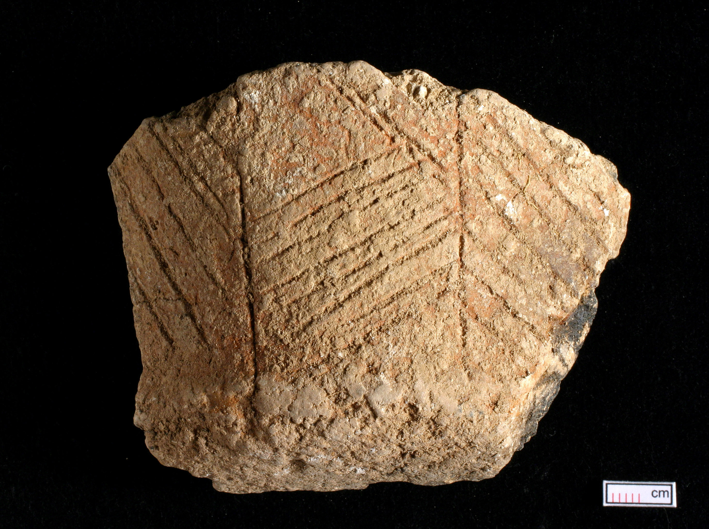 Fragment of Neolithic pottery with grooved line decorations on its surface