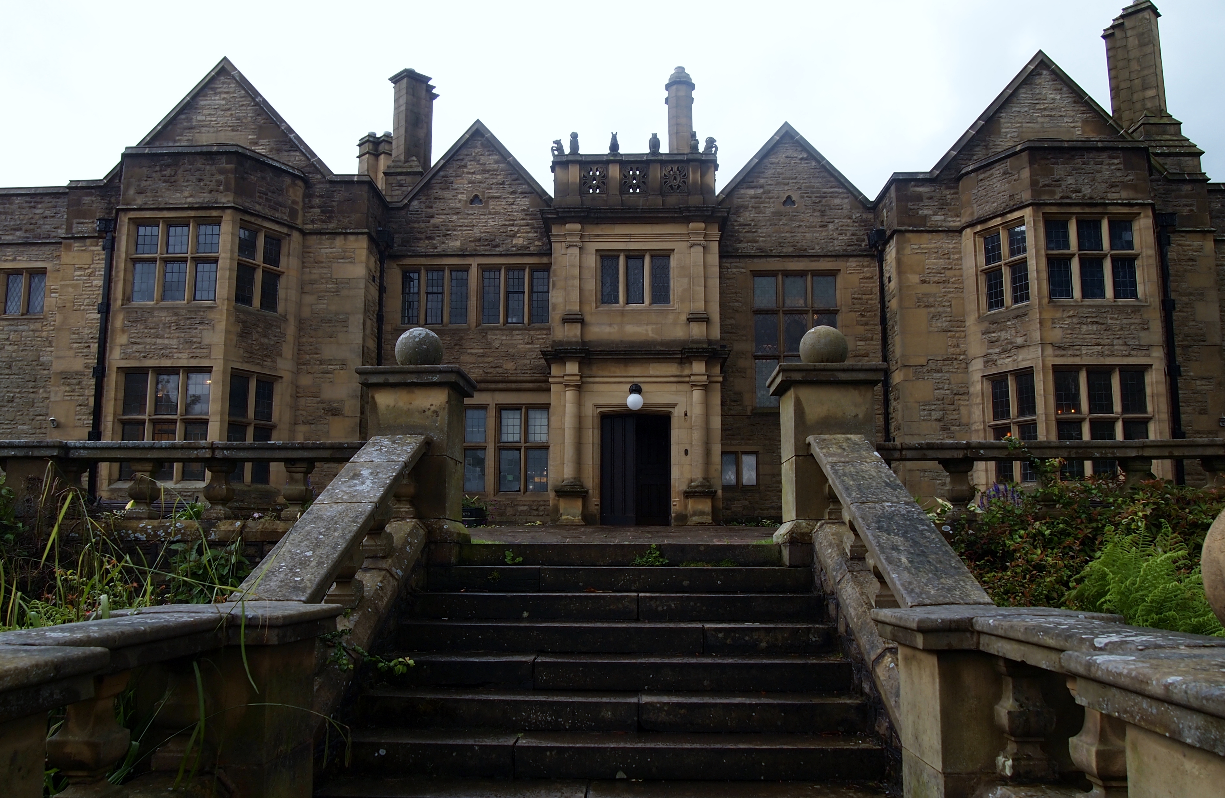 Colour photograph showing the exterior of a grand house, with steps leading up to an impressive entrace.