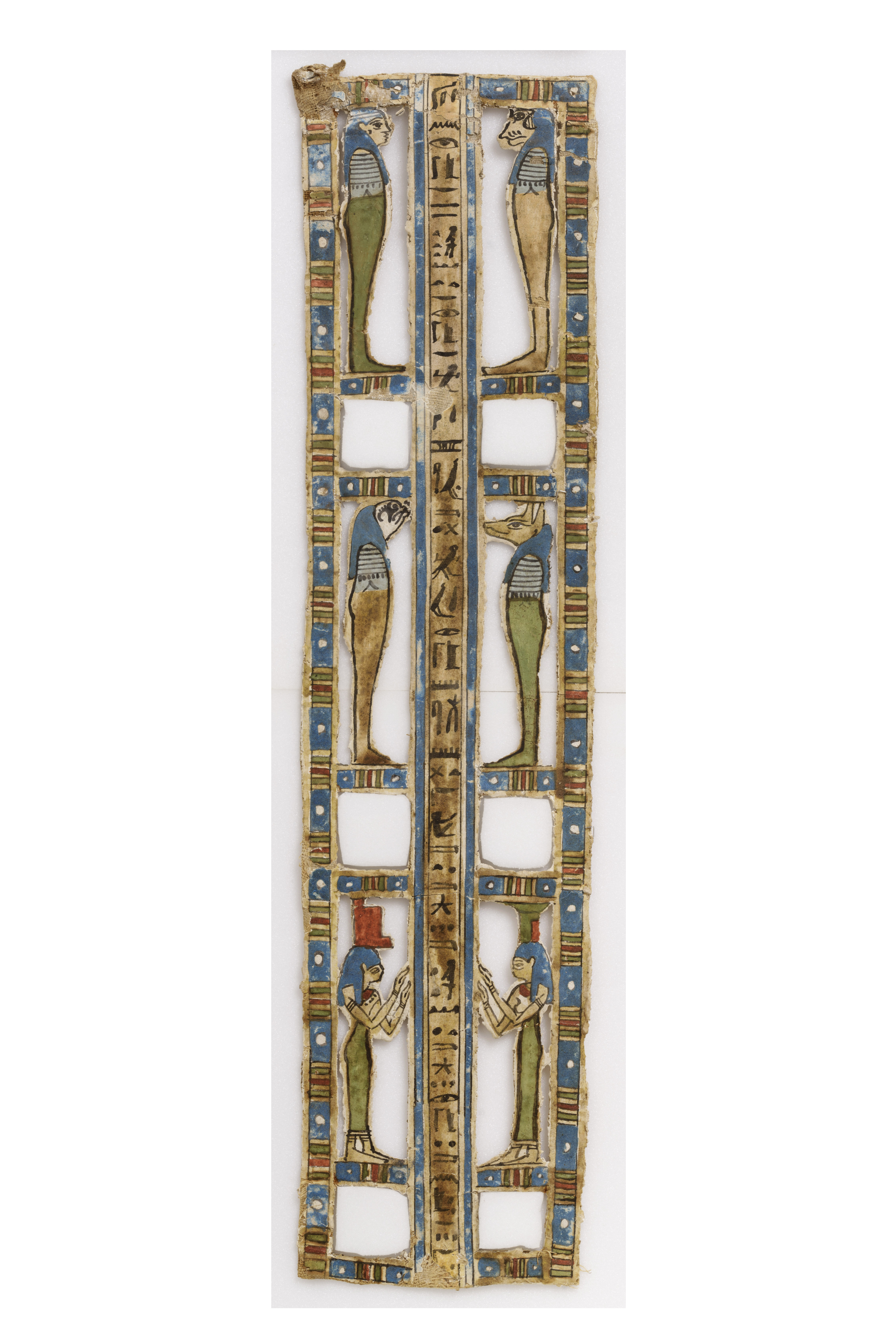 An Egyptian decorative panel featuring vertical hieroglyphics in the center, framed by figures of gods and goddesses. On each side of the hieroglyphs, there are four figures, two at the top with animal heads and two at the bottom with human forms, all wearing traditional headdresses. The design is bordered by colorful geometric patterns in blue, red, and gold. The panel shows intricate detailing and symmetry.