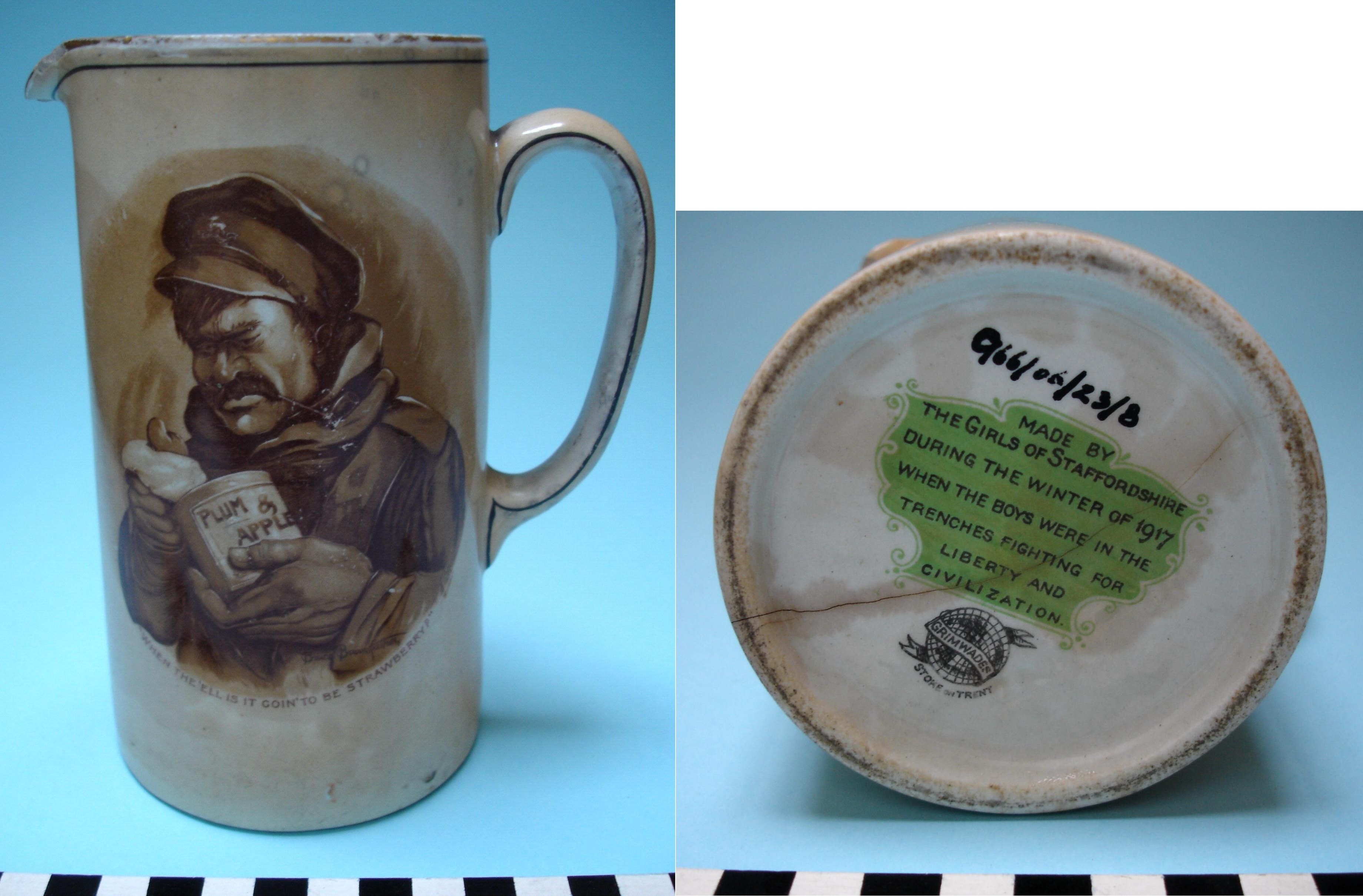 A World War I ceramic jug featuring an image of a soldier holding a tin labeled “Plum & Apple” with the caption “When the 'ell is it goin’ to be strawberry?”. The base inscription reads that it was “made by the girls of Staffordshire during the winter of 1917” for soldiers fighting in the trenches.