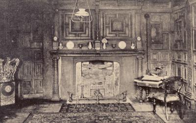 Interior view of a country inn with wooden panelling above a fireplace