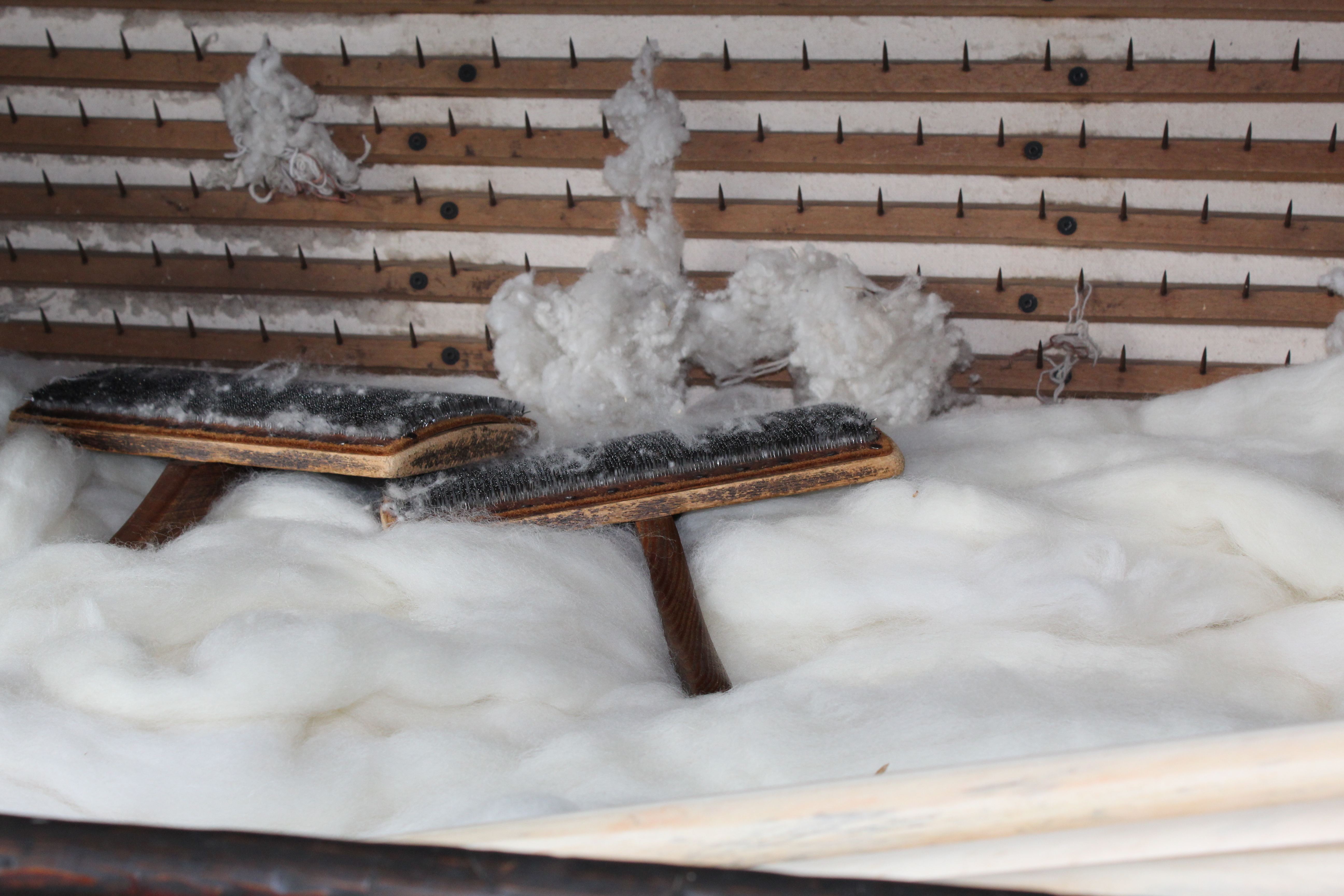 Close up of the carding machine, showing rows of metal teeth used to tease the fleece.