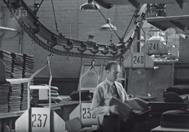 Black and white film still showing the Burtons factory in 1950