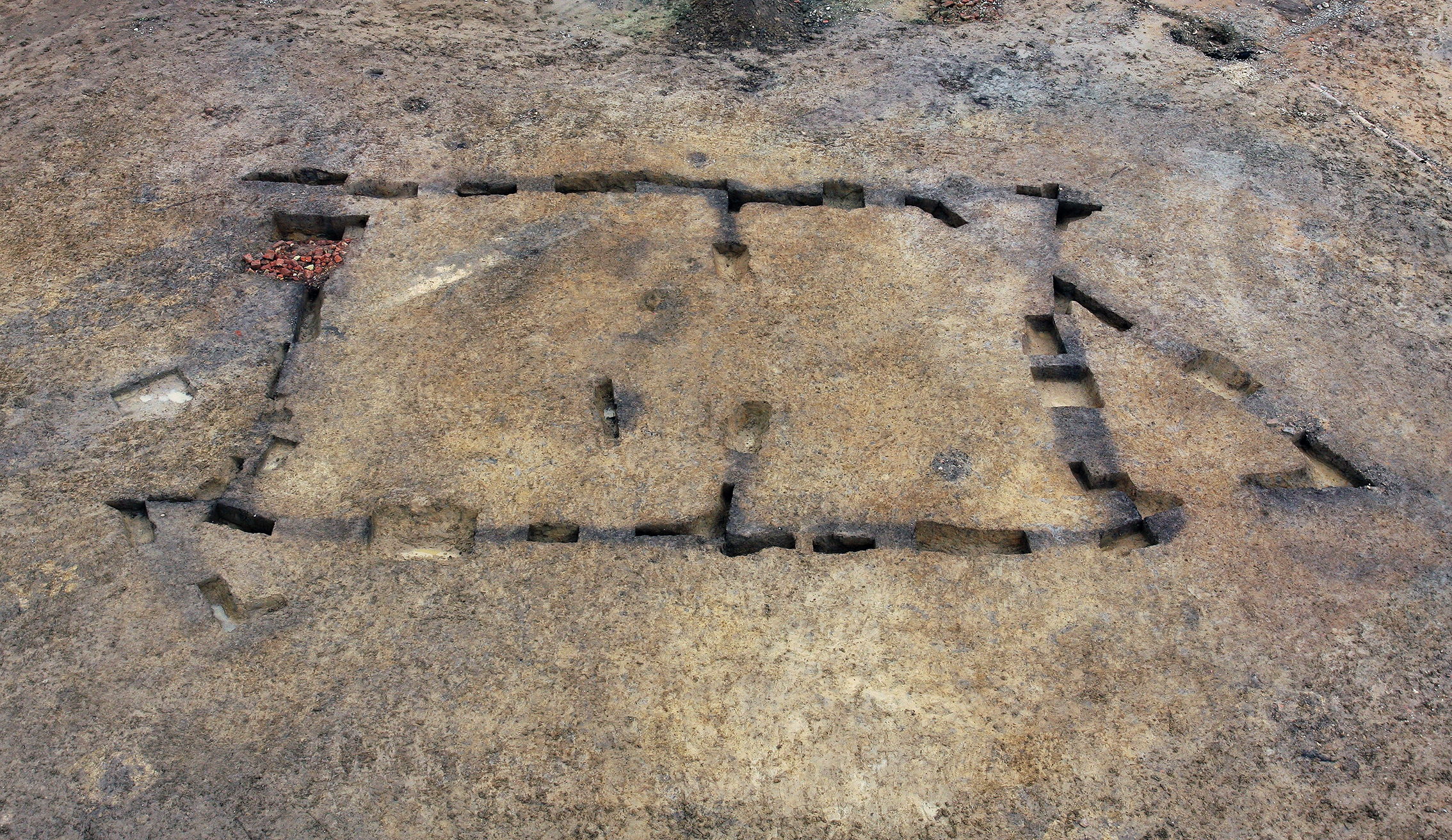 Area of ground showing post holes of Neolithic house that has been excavated by archaeologists