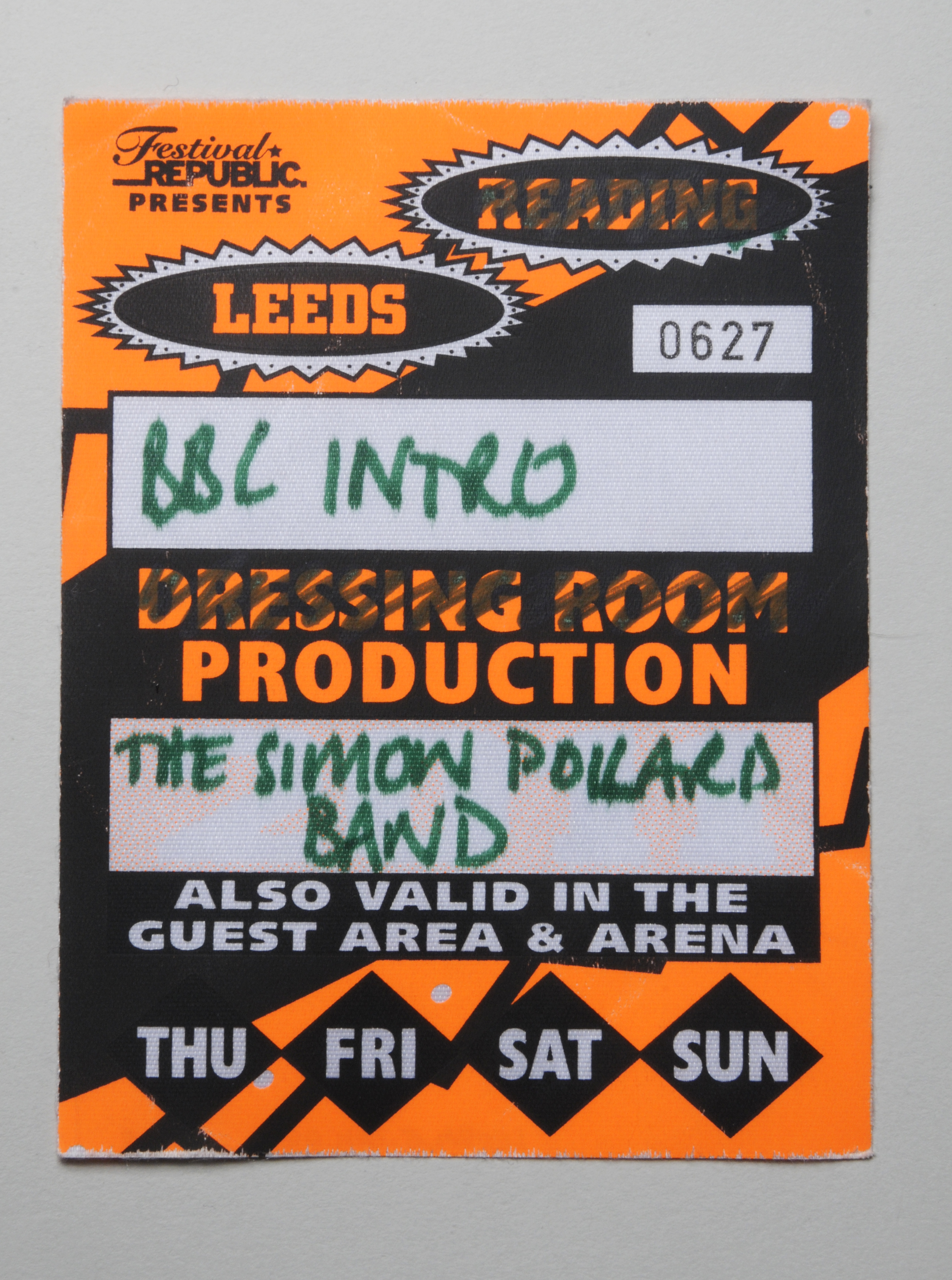 Orange and black print design on thin card.  Pass number 0627 with 'BBC INTRO' and 'Simon Pollard Band' written  on it.