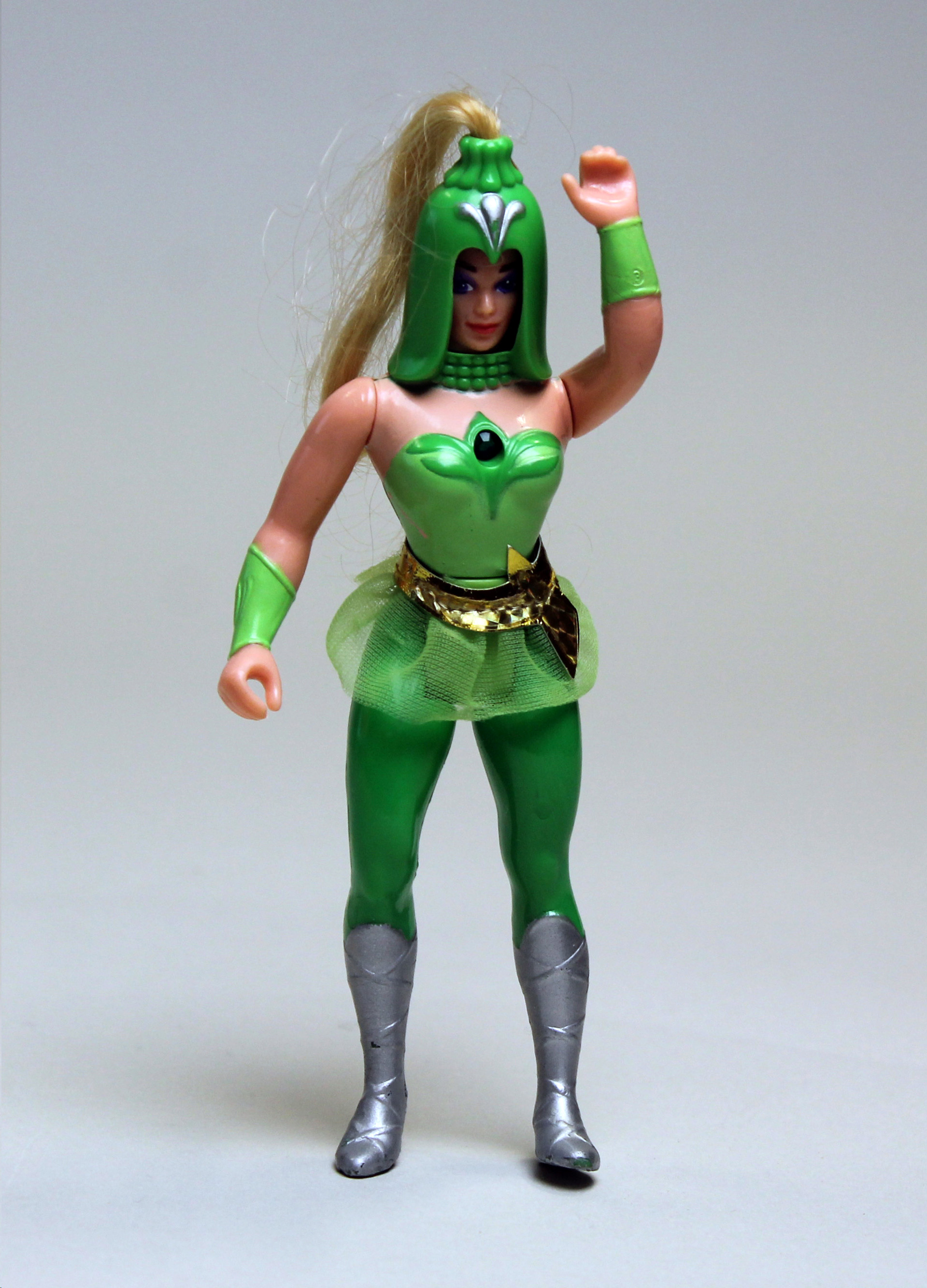 Colour photograph of a figurine of a female character wearing a green costume, including a large, green helmet