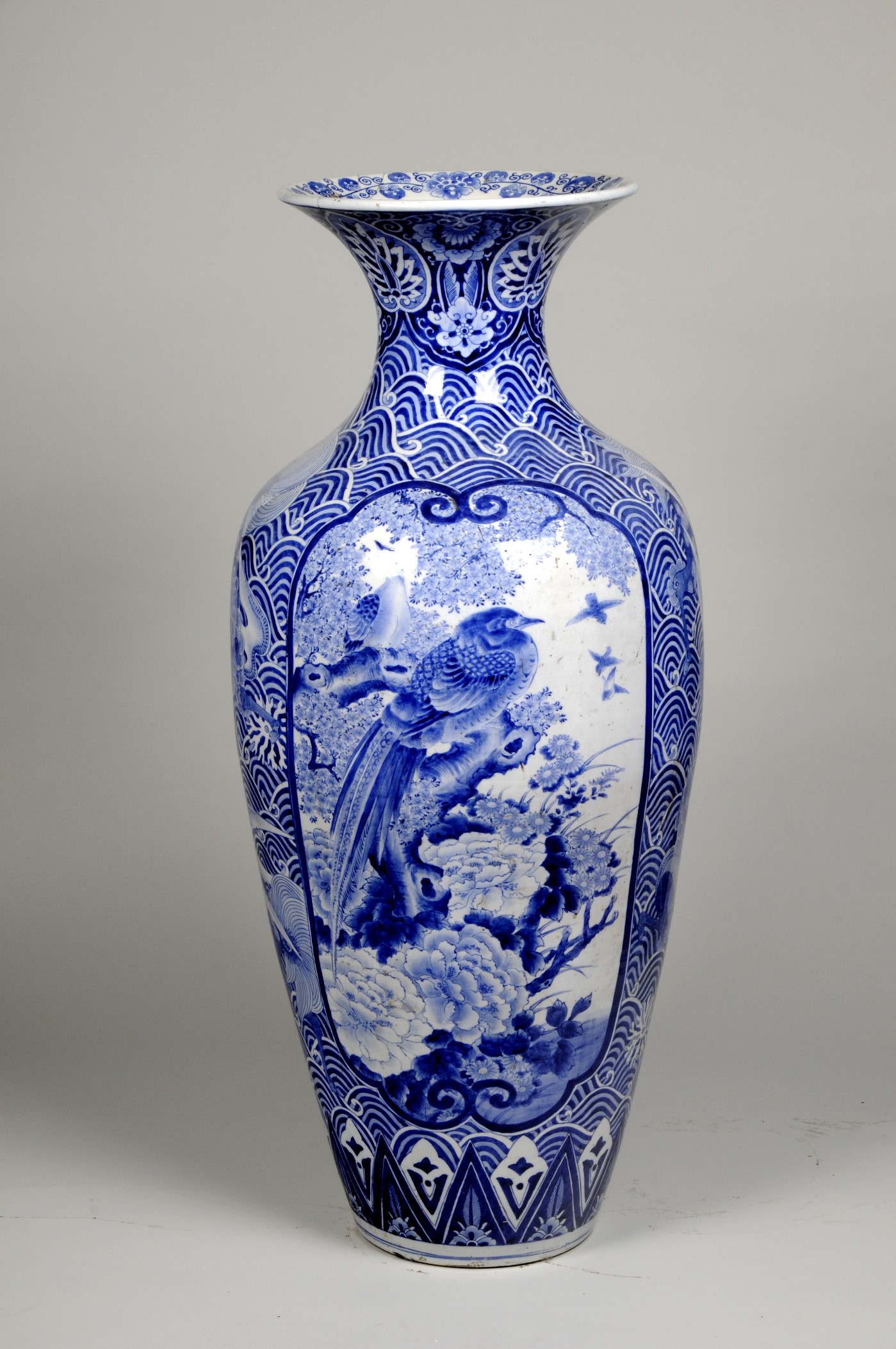 Blue and white ceramic vase with an image of a bird in the centre and wave motifs around it