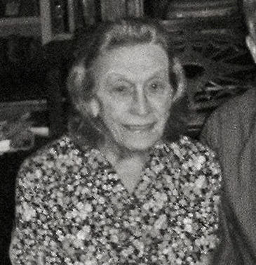 Black and white photograph showing an elderly lady wearing a flowery blouse.