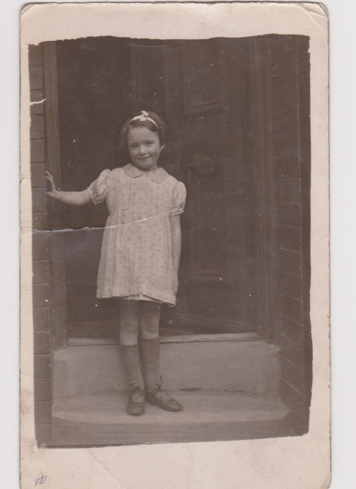 Photo of Annie Clarke standing on the doorstep of her house in Marley Place, Beeston
