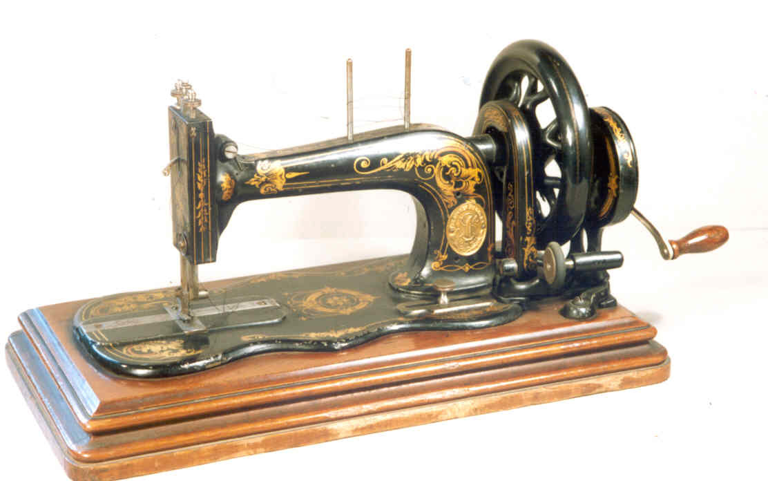 Black hand operated personal sewing machine with gold coloured decoration in the shape of leaves