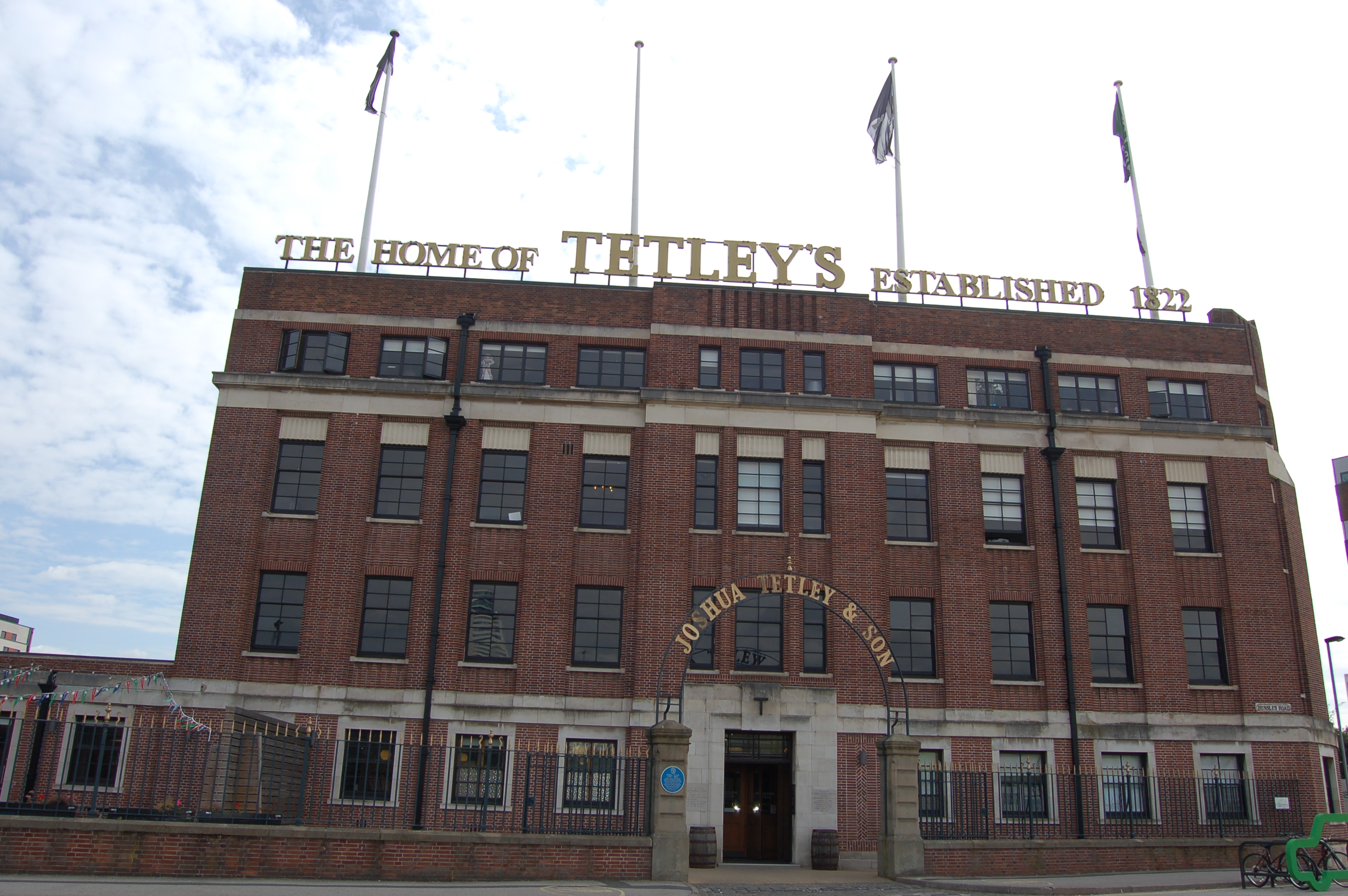 Contemporary photograph of a large, symmetrical brick building, with five windows on either side of the imposing doorway.