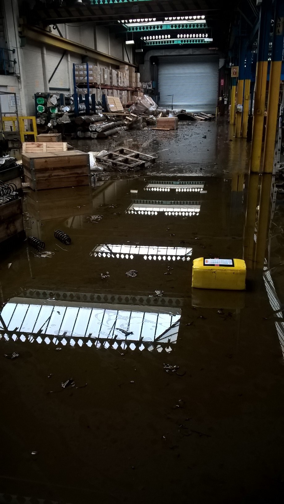 Colour photograph showing a warehouse in Leeds with half the floor underwater.
