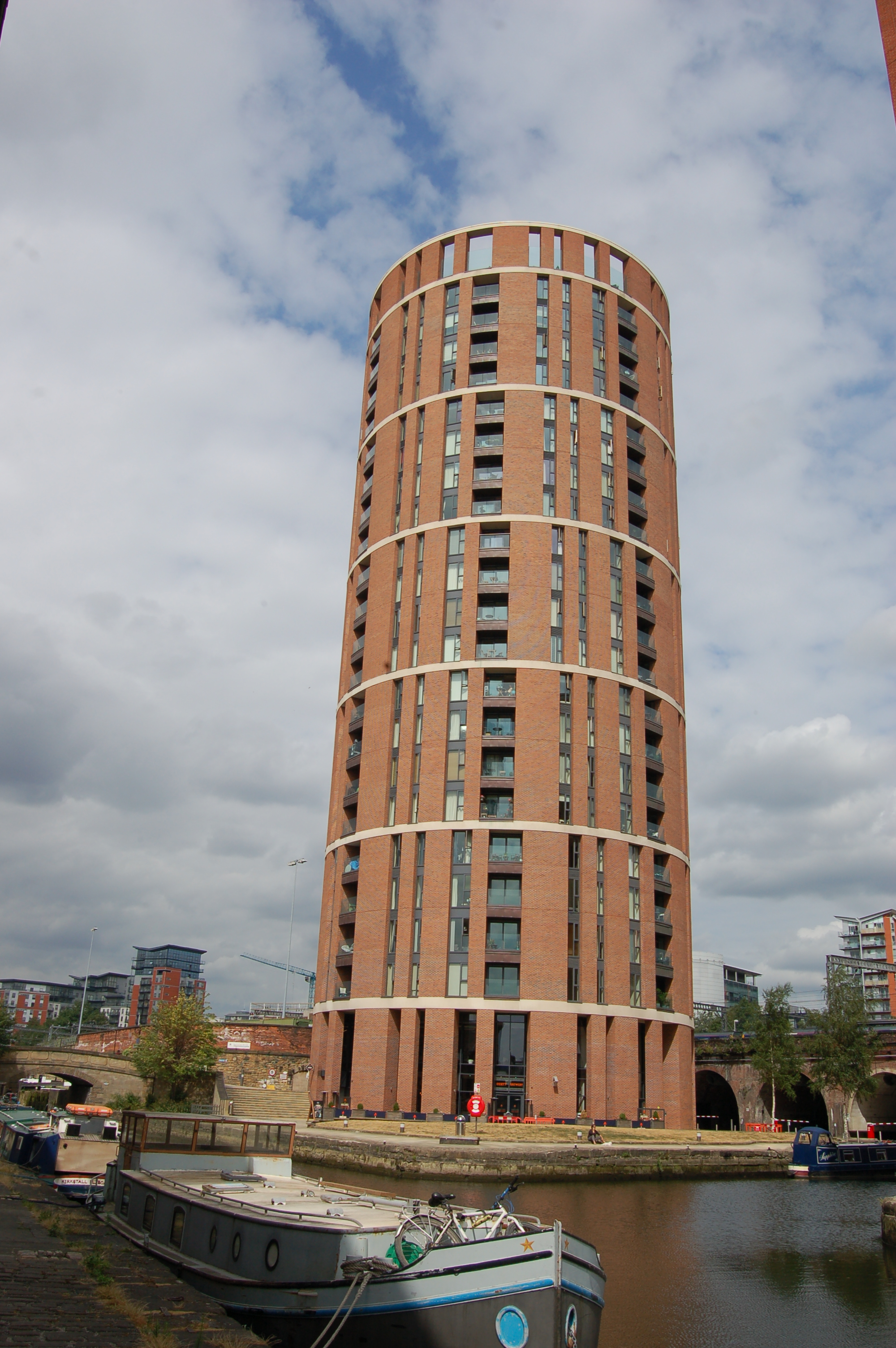 Contemporary photograph of a tall, cylindrical building that twists at fouor storey intervals