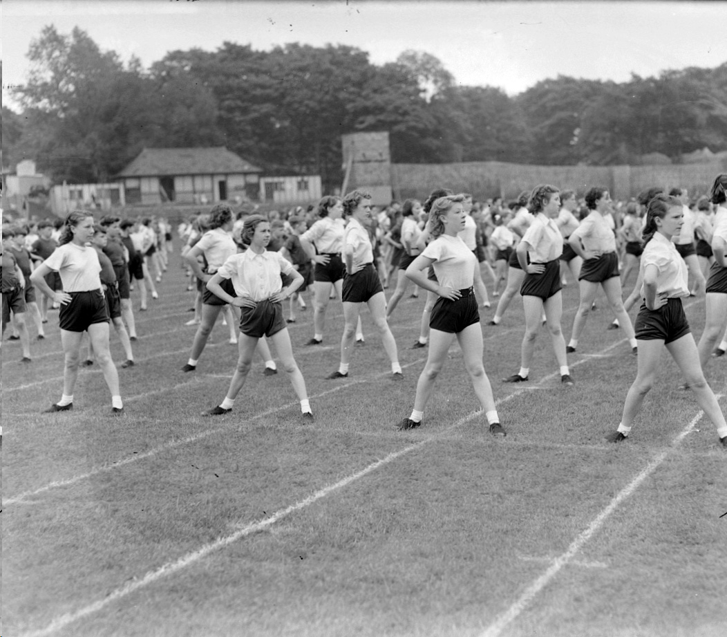 Black and white photograph showing lines of girls in PE kit
