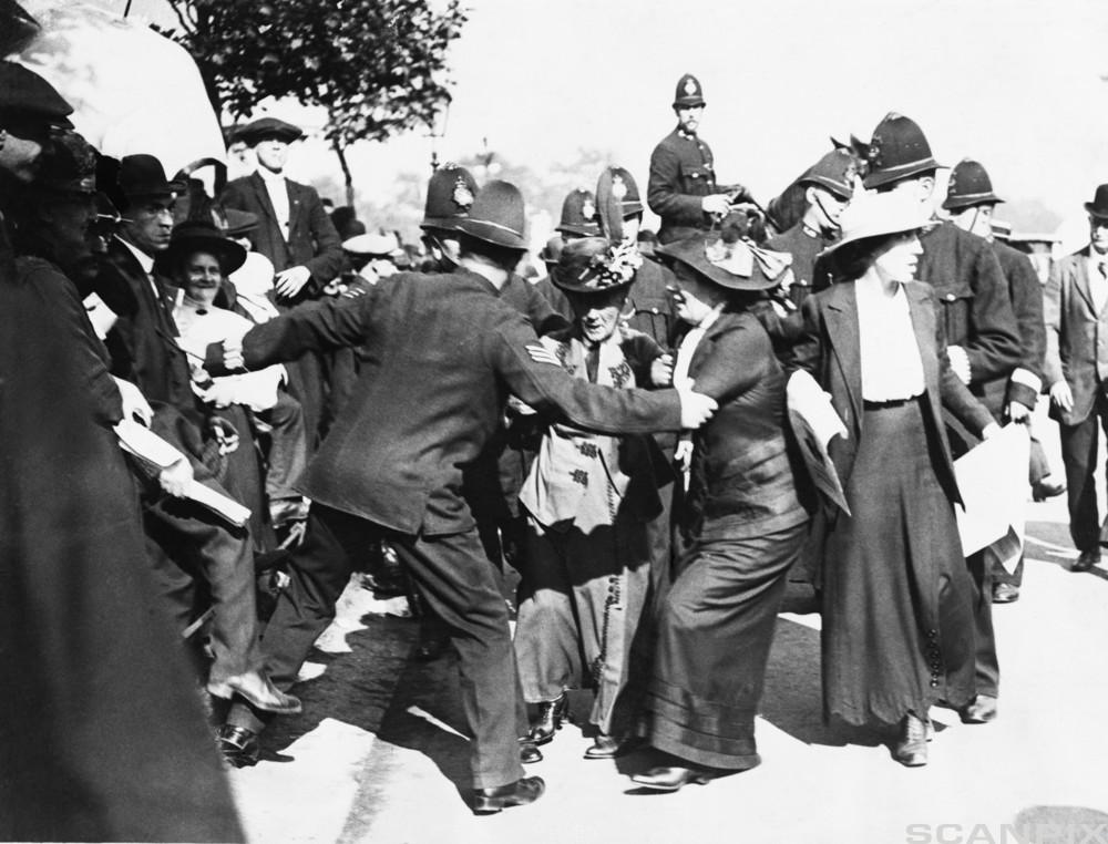 Black and white photograph showing women being physically restrained by police