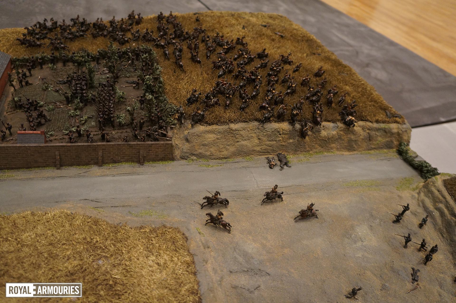 Close up photograph showing several model soldiers fighting in farm roads and fields, some on horseback