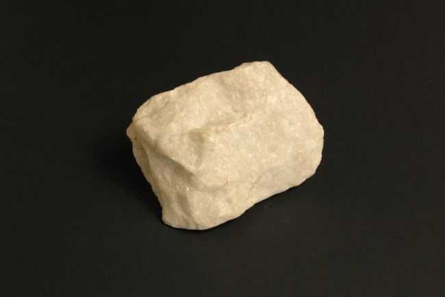 Lump of white marble that looks crystalline and has rounded angles to it.