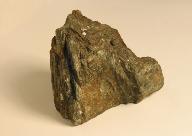 Dark rock with different colours in it ranging from dark brown to orange. Folded layers can be seen.