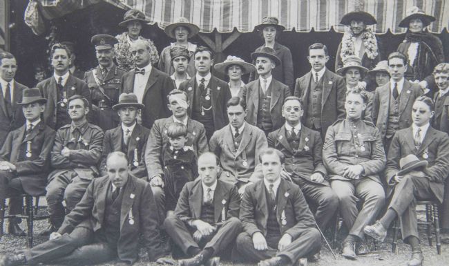 Black and white photograph showing soldiers and St. Dunstan's staff. Soldiers are wearing suits with their medals pinned to their jackets.