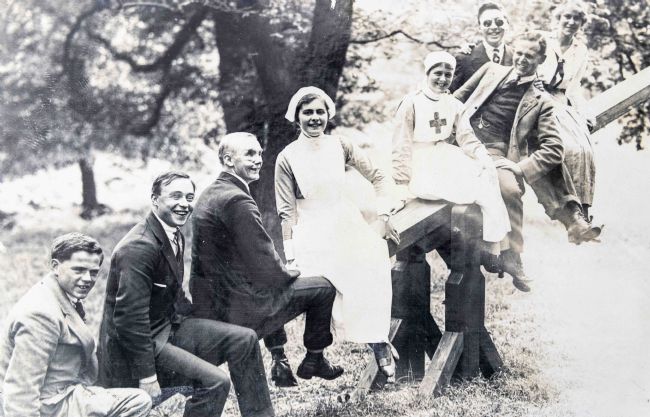 Black and white photograph of some blind veterans on a see-saw with VAD nurses.