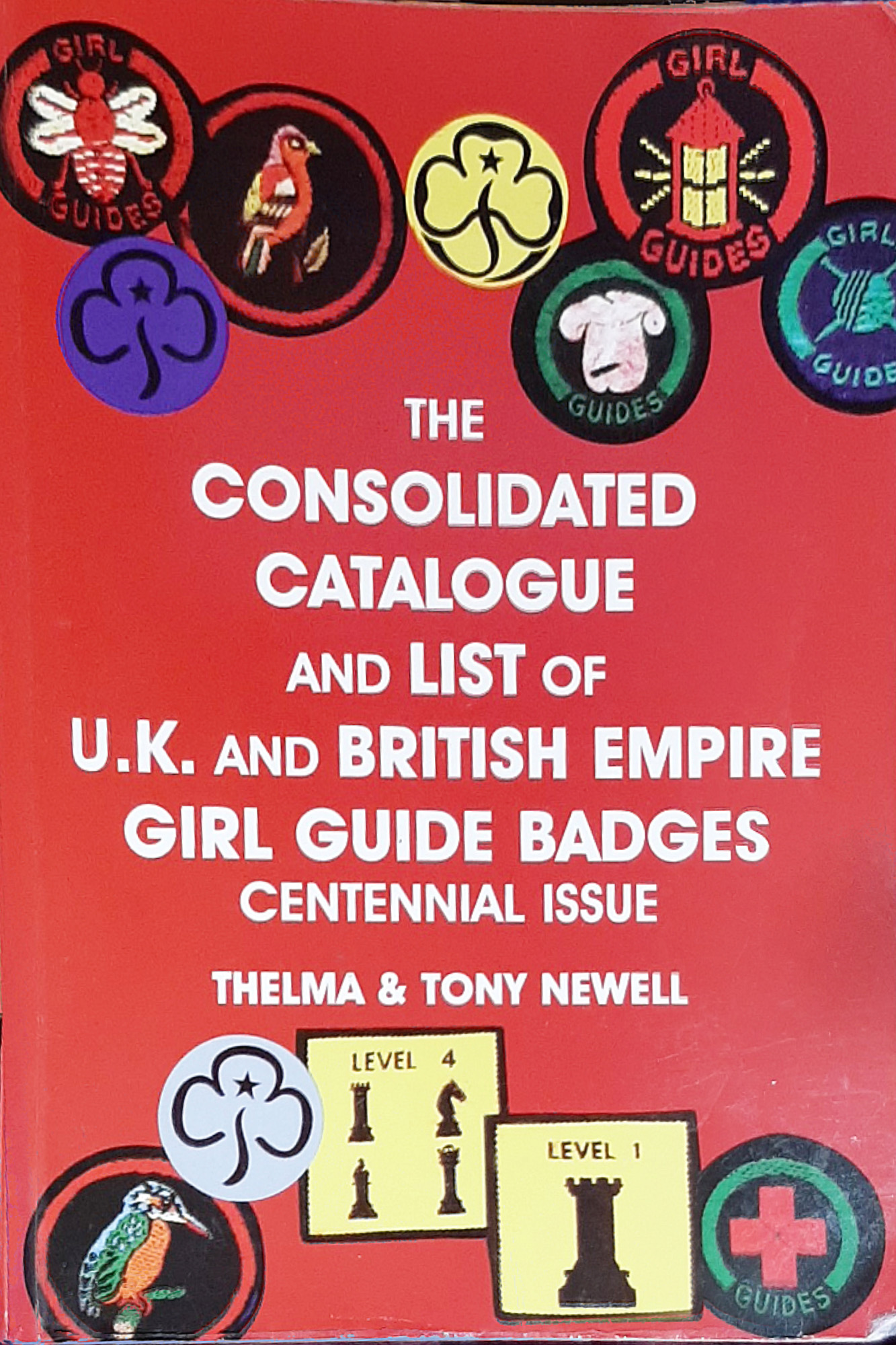Front cover of a Girl Guide book showing a range of different badges