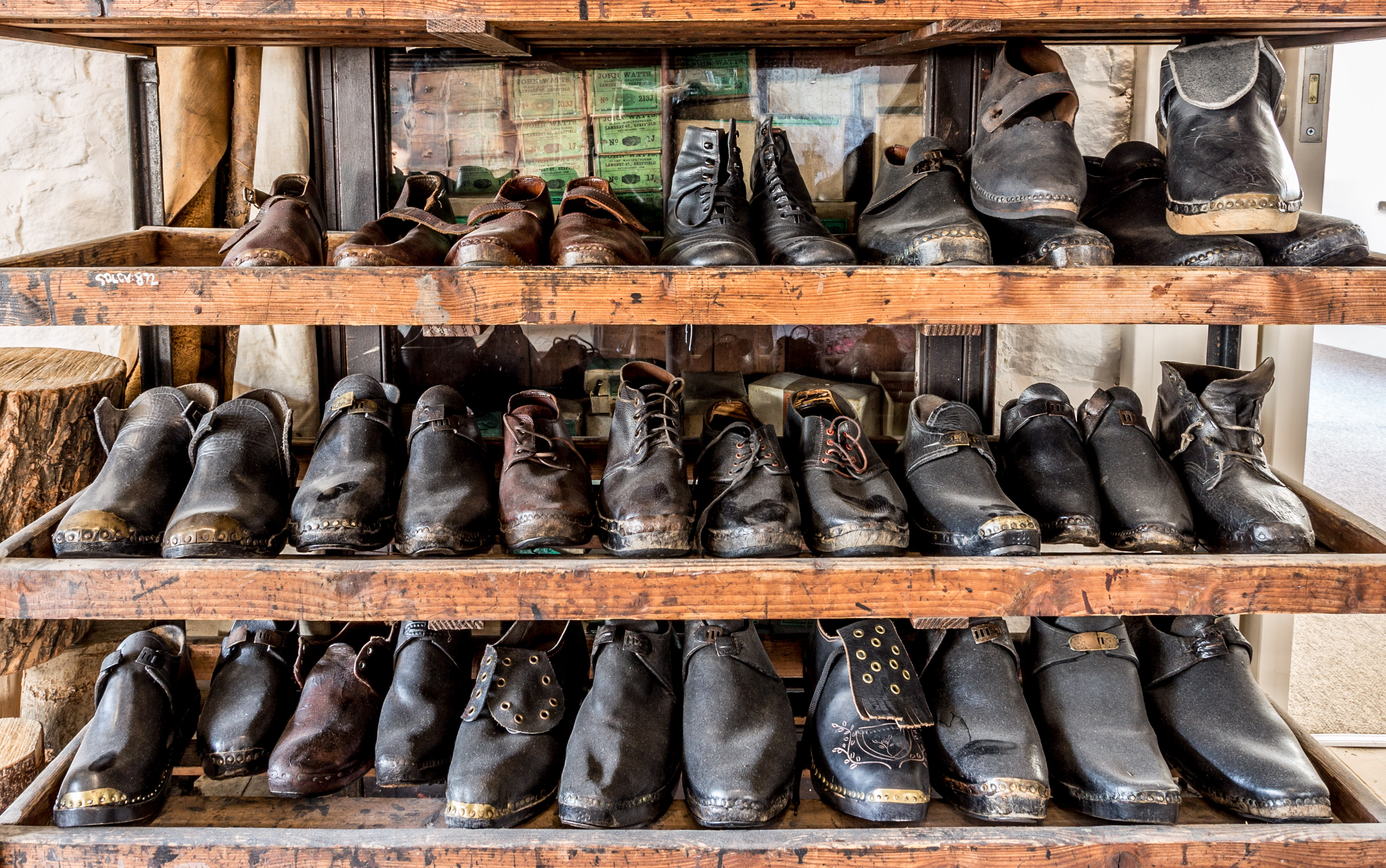 Colour photograph of three shelves of Edwardian clogs, in all different sizes and various designs
