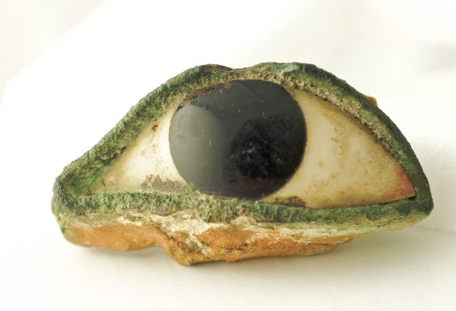 Stone or marble eye from a statue.  It looks like it has green eyeliner.